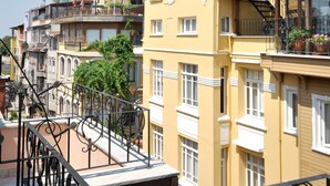 A multi-story building with balconies, a mosque with minarets, and a clear blue sky. - Side Hotel (Istanbul)
