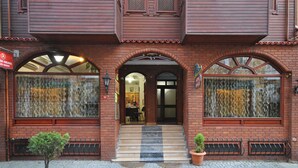 A brick building with large arched windows and a small entrance. - Side Hotel (Istanbul)
