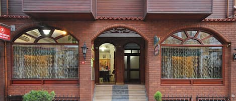 A brick building with large arched windows and a small entrance.