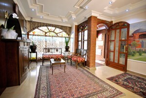 A traditional interior with a reception desk, seating area, and a view of a mural.
