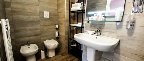 A modern bathroom with a bidet, a sink, and a mirror.