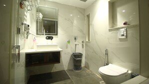 A modern bathroom with a white sink, mirror, and toilet.