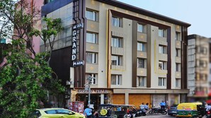 A multi-story hotel with a prominent 'GRAND PLAZA' sign, featuring a modern facade with large windows and balconies.
