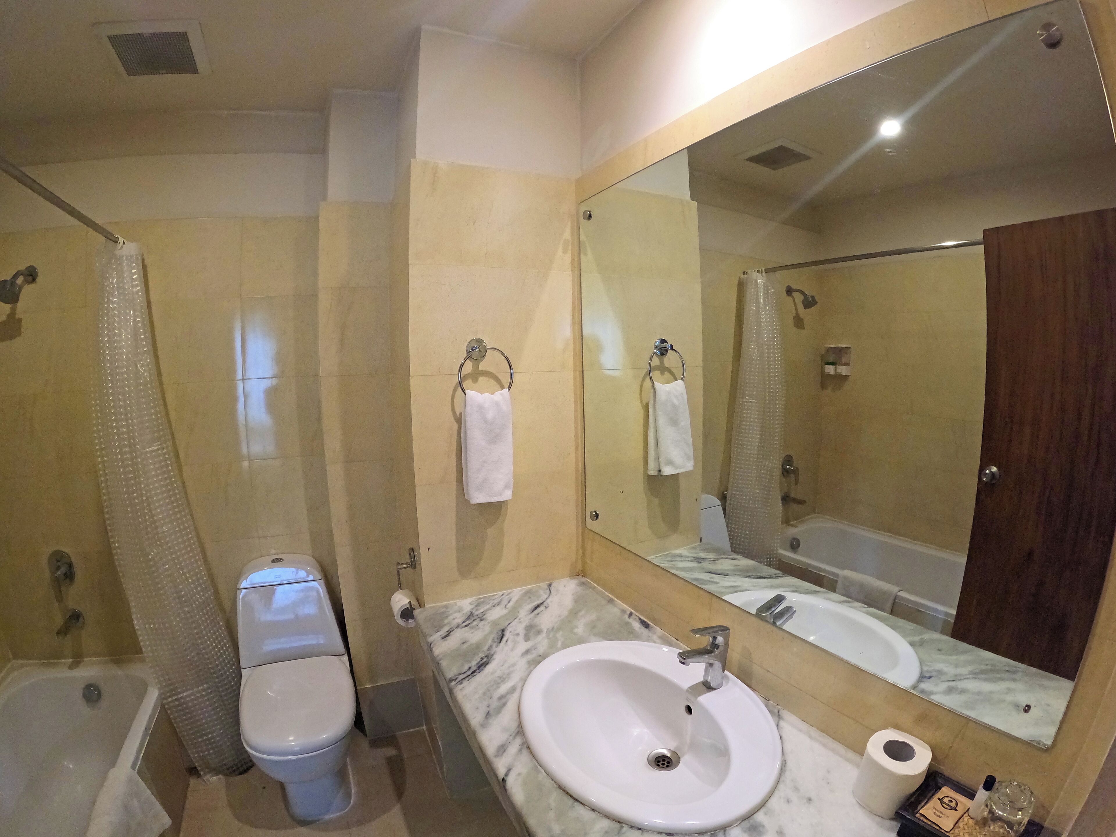 A bathroom with a toilet, sink, and shower.
