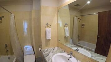 A bathroom with a toilet, sink, and shower.