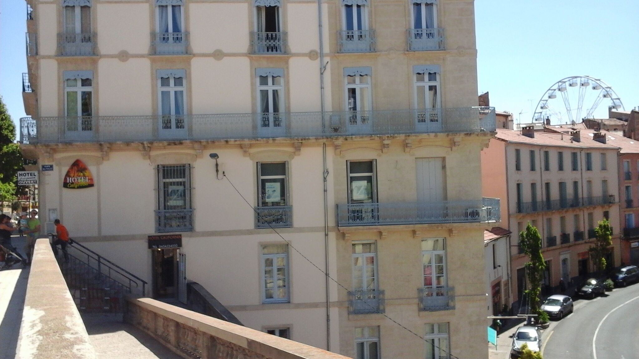 A multi-story hotel with balconies, a visible sign for 'Hotel California', and a Ferris wheel in the background.