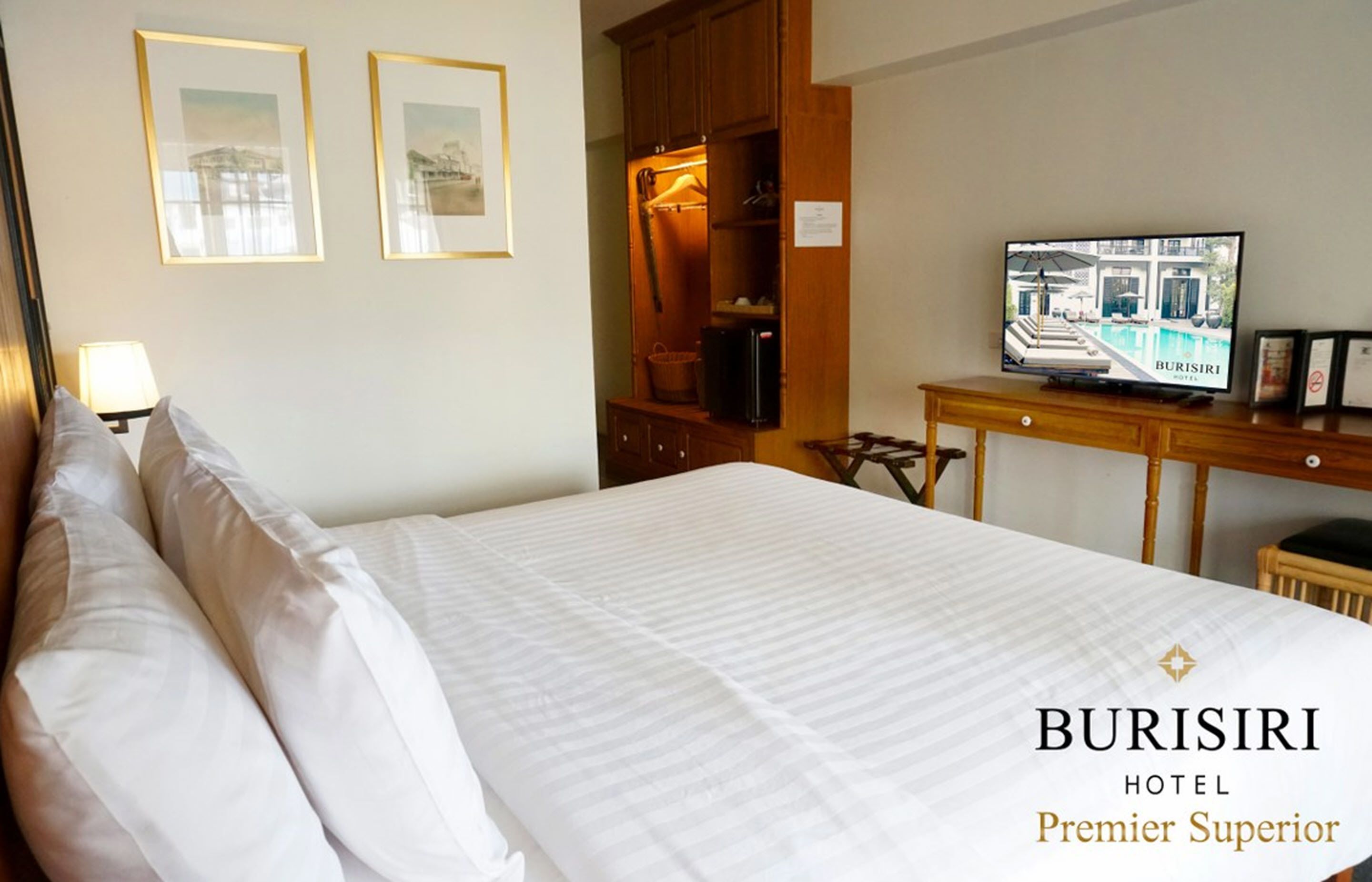 A hotel room with a bed, a television, a desk, and a wardrobe.