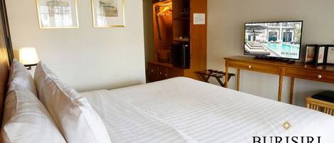 A hotel room with a bed, a television, a desk, and a wardrobe.