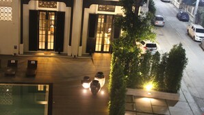 A hotel entrance with a wooden floor, large doors, and a small garden area with a bench. - Buri Siri Hotel (Chiang Mai)
