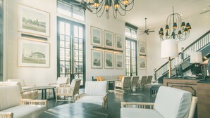 A spacious lobby with wicker furniture, a central round table, and framed pictures on the walls. - Buri Siri Hotel (Chiang Mai)