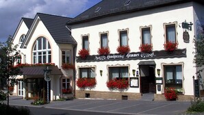 Un edificio con un letrero que dice "Landgasthof Gemmer" y un techo negro.