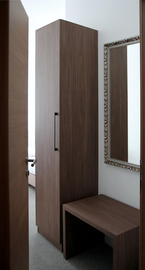 A room with a wardrobe, a bench, and a mirror with an ornate frame. - Hotel Restaurant Gemmer (Rettert)