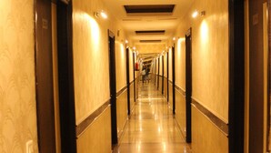 A long, well-lit hallway with doors on both sides, leading to rooms. - Tulalip Hotel (Gurugram)