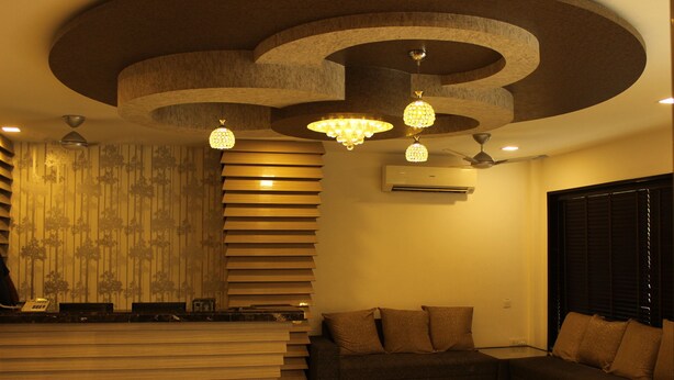 A modern living room with a sofa, a staircase, and a chandelier. - Tulalip Hotel (Gurugram)