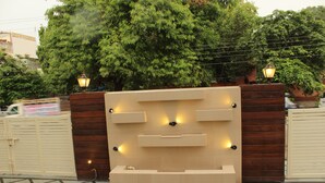A gated entrance with a modern design, featuring a wall-mounted light fixture and a bench. - Tulalip Hotel (Gurugram)