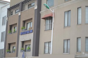 A multi-story building with balconies, a sign reading "INTELLECTUAL HOTEL," and a street lamp.
