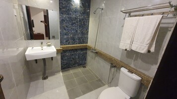 Un baño moderno con un lavamanos blanco, ducha e inodoro.