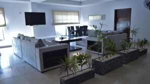 Una sala de estar moderna con un sofá, una mesa de centro y plantas en macetas.