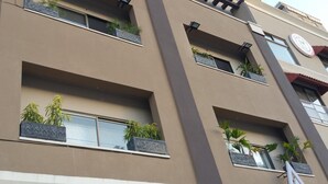 Un edificio de varios pisos con balcones, cada uno adornado con macetas.