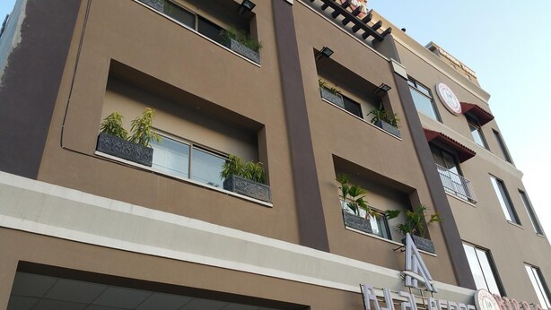 Un edificio de varios pisos con balcones, ventanas amplias y plantas decorativas.