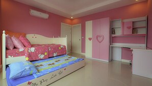 A pink-themed bedroom with a bed, a desk, and a wardrobe. - Baan Taradon By Puppap (Hua Hin)