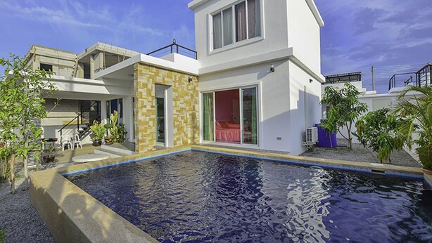 A modern two-story house with a swimming pool, a patio with chairs, and a small garden area. - Baan Taradon By Puppap (Hua Hin)