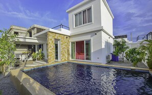 A modern two-story house with a swimming pool, a patio with chairs, and a small garden area. - Baan Taradon By Puppap (Hua Hin)