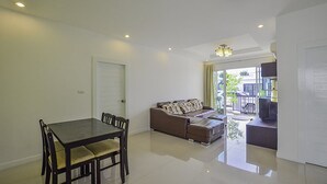 A spacious living room with a dining area, a sofa set, and a television. - Baan Taradon By Puppap (Hua Hin)