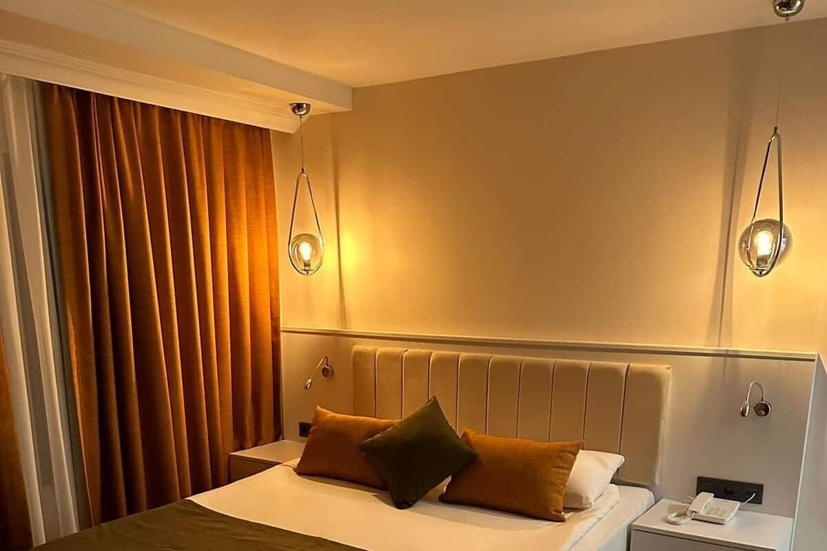 A neatly arranged hotel room with a bed, bedside tables, and a nightstand.