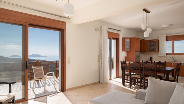 Un vaste espace de vie comprenant un balcon, un coin repas et une cuisine.