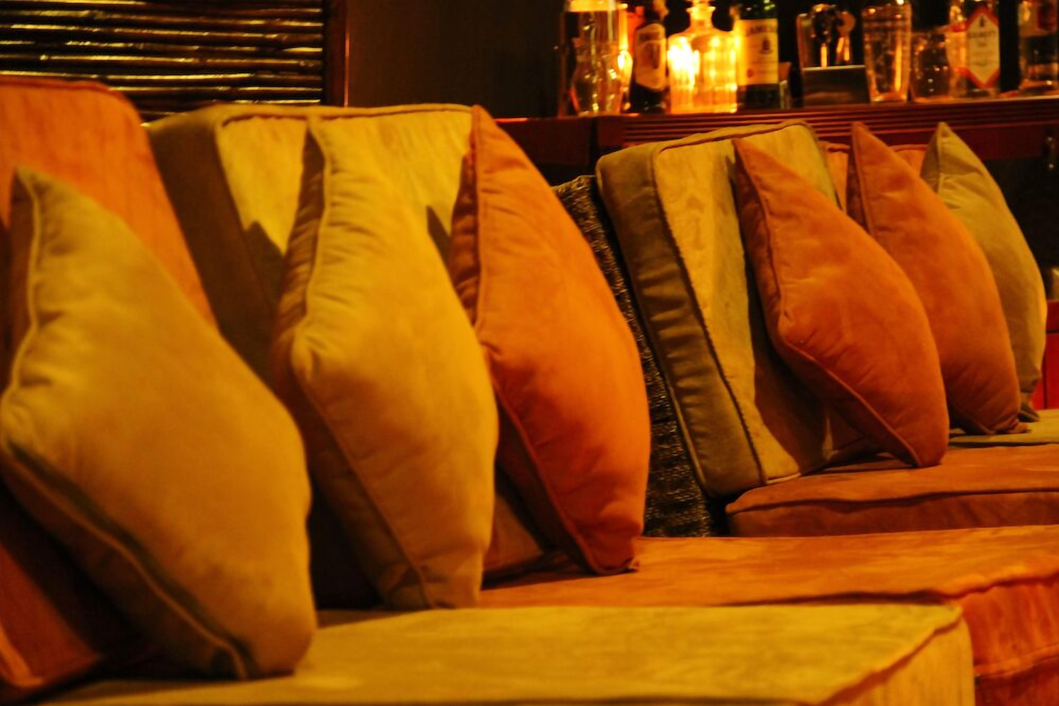 A row of sofas with multiple cushions in a bar area.