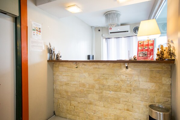 A kitchen with a stone backsplash, a ceiling fan, and a window with curtains.