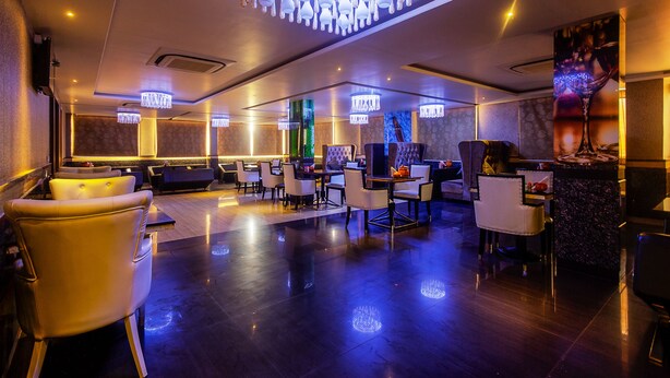 A modern hotel lobby with a polished floor, seating areas, and ambient lighting. - Treebo Shivani (Indore)