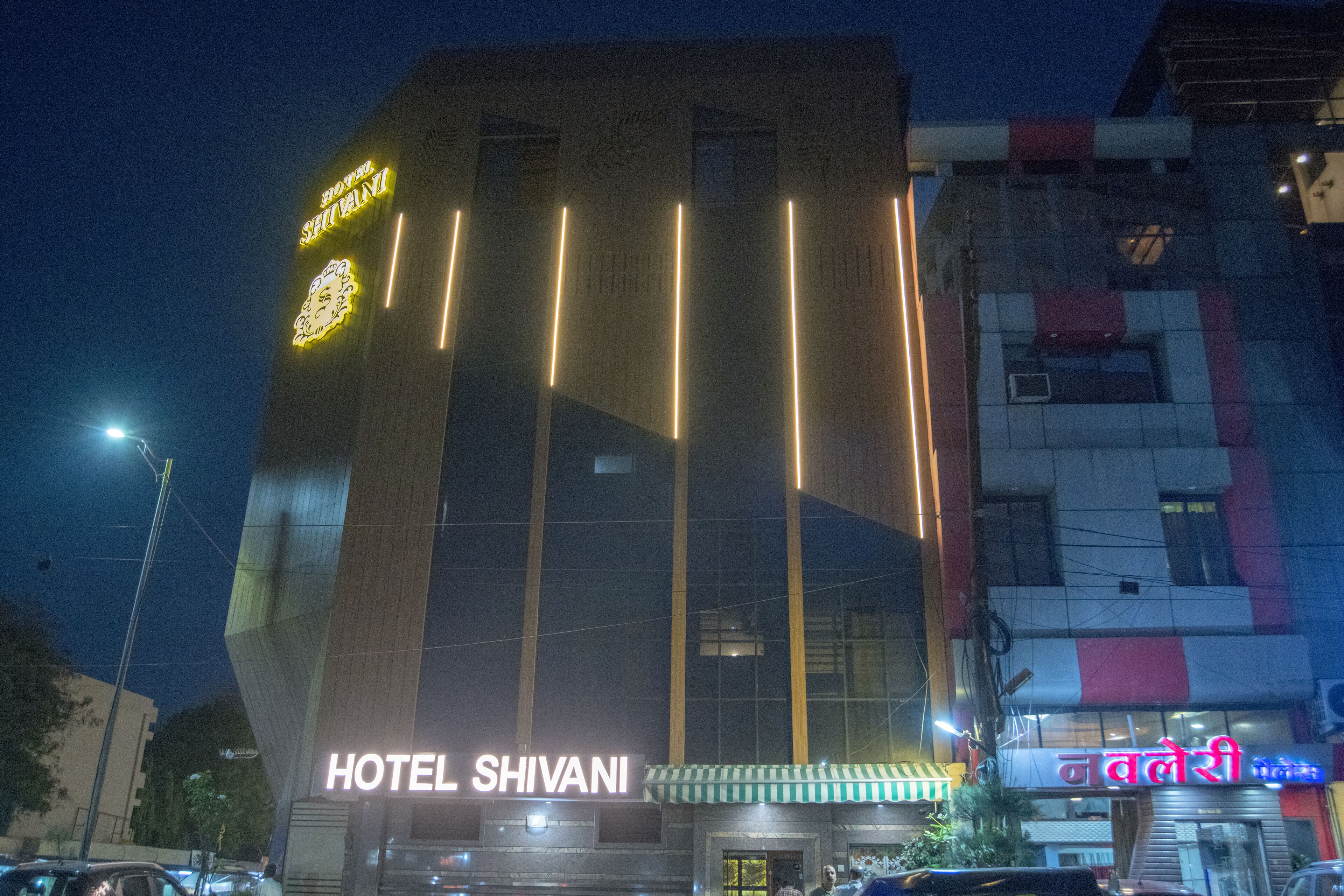 A hotel with a modern facade, illuminated signage, and a visible entrance.