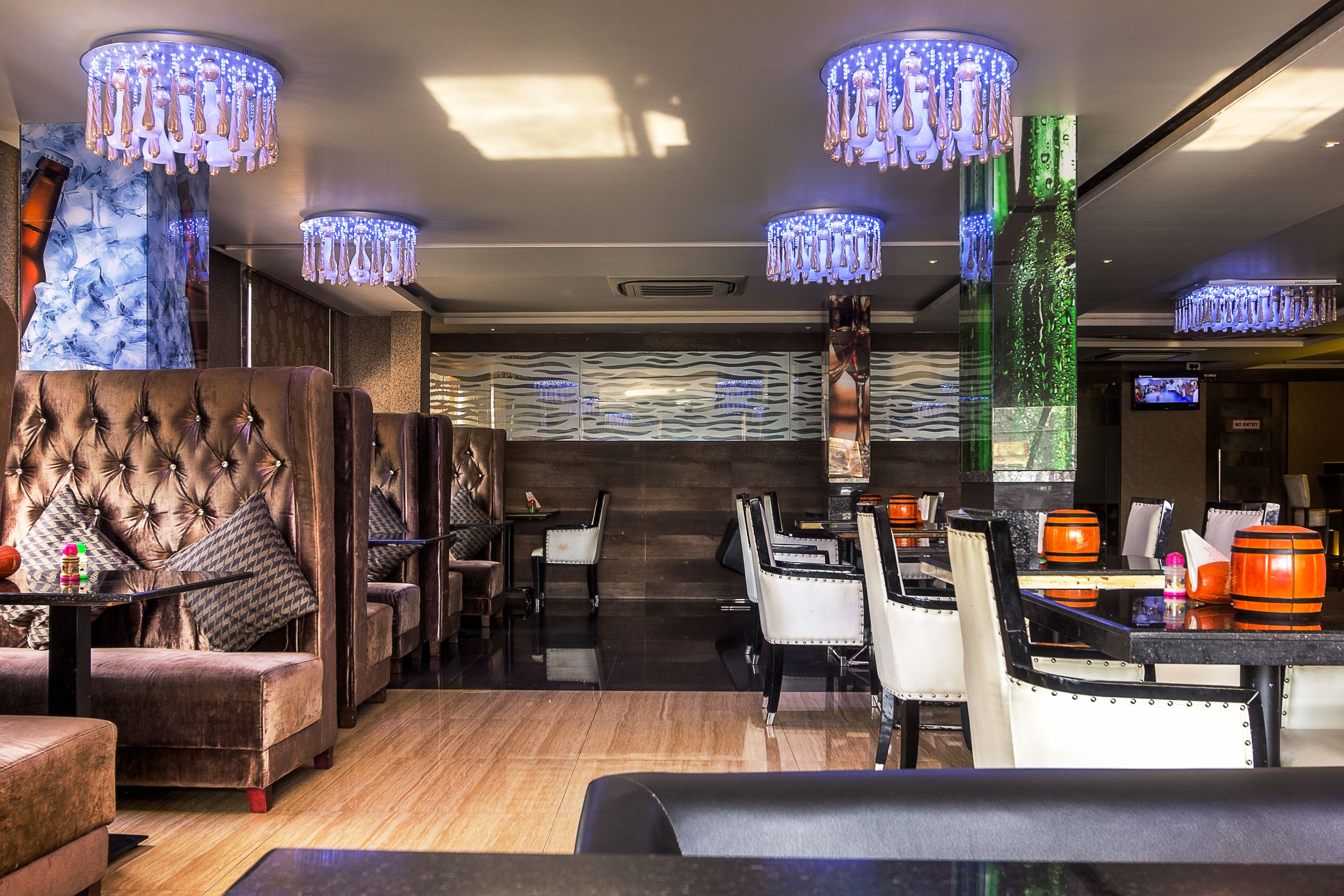 Et moderne loungeområde med bløde siddepladser, stemningsfuld belysning og en bar.