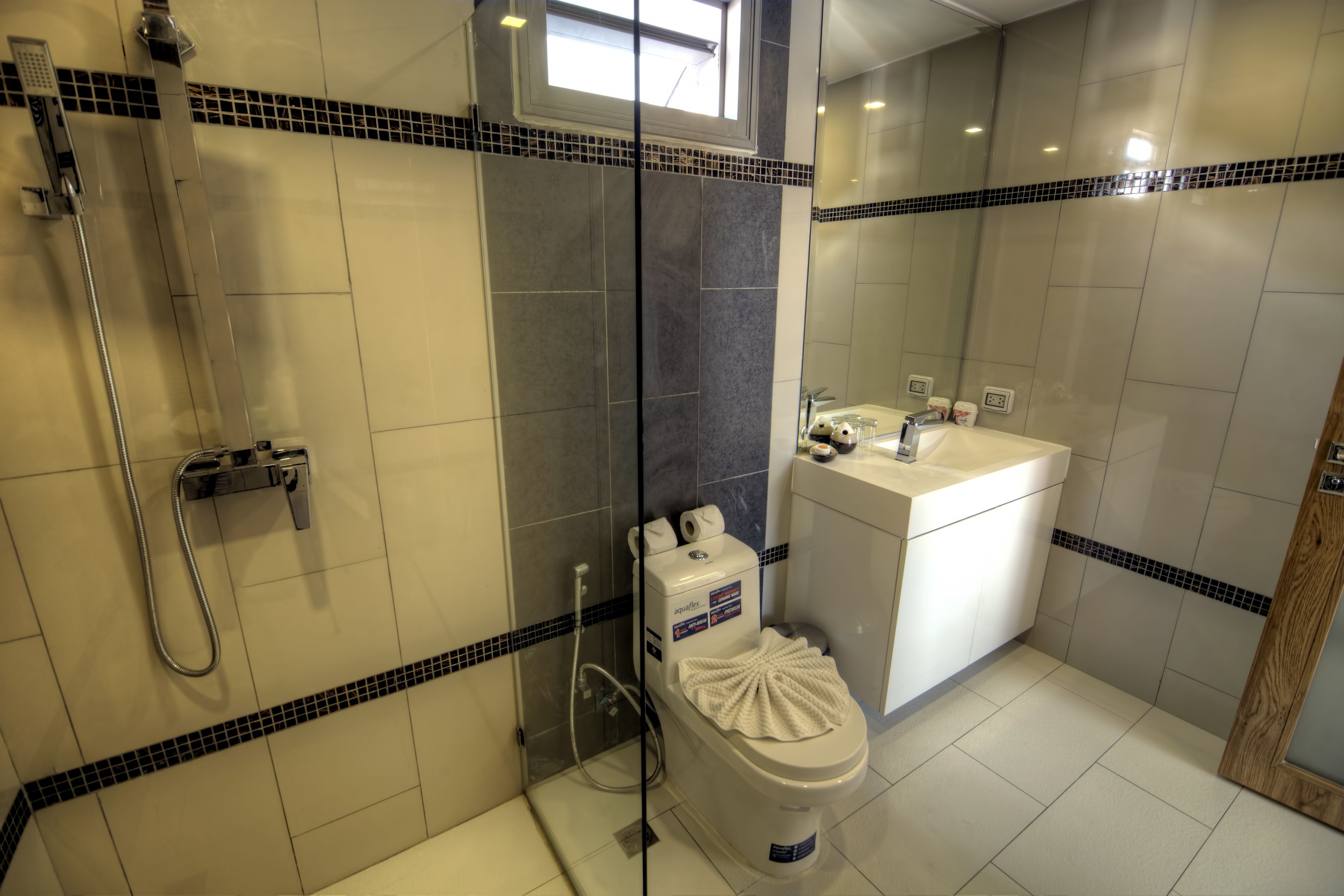 A modern bathroom with a shower, toilet, and sink.