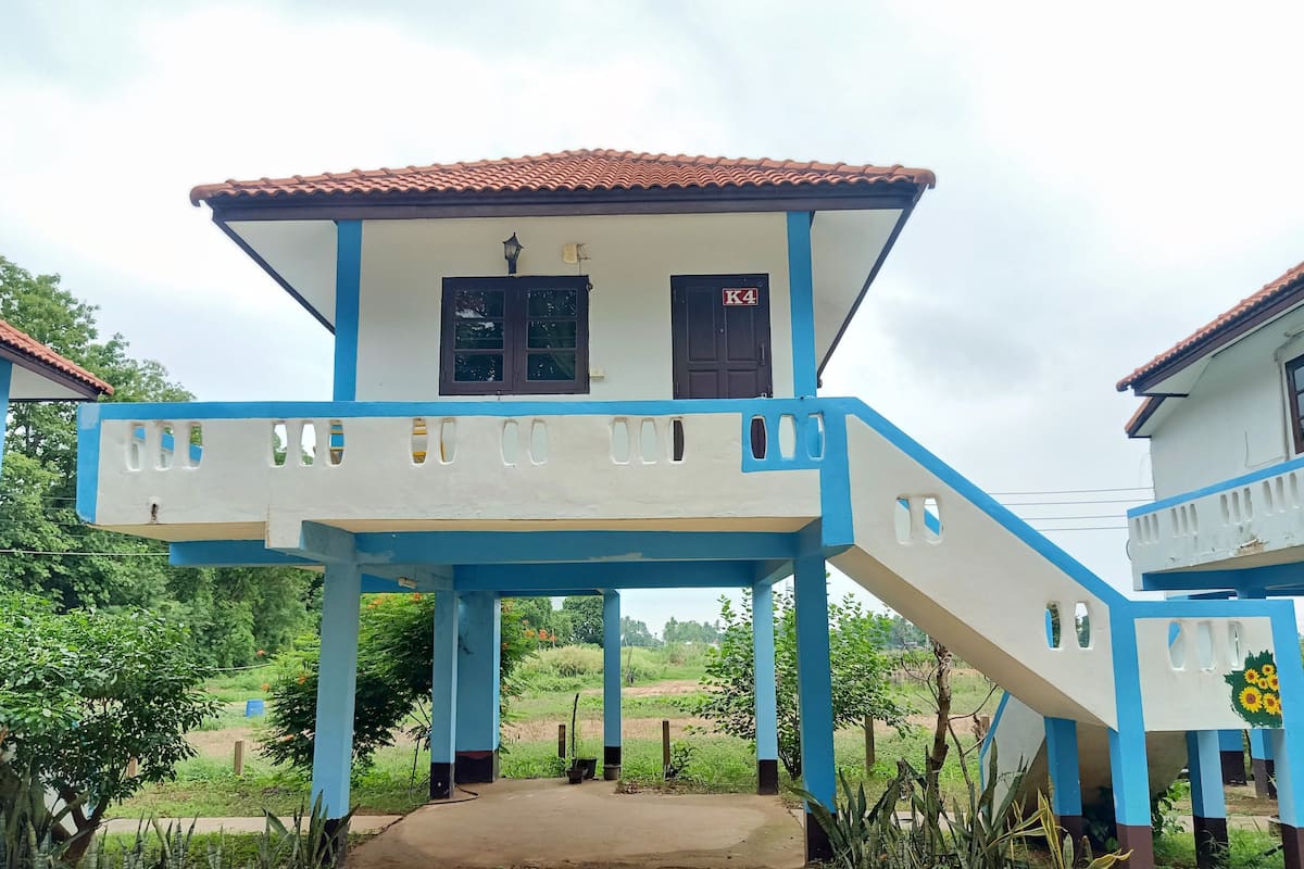 A two-story building with a blue and white color scheme, a covered porch, and a door marked "K4".