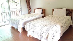 Habitación con dos camas, balcón y ventilador de techo.