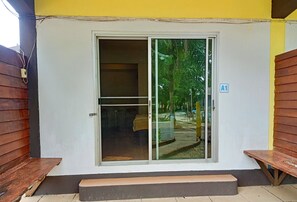 A building entrance with a sliding glass door, a bench outside, and a sign indicating room A1. - Wangnamkam Riverside Resort (That Phanom)