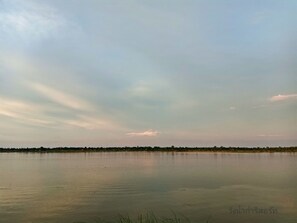 A calm lake with a clear sky and distant shoreline. - Wangnamkam Riverside Resort (That Phanom)