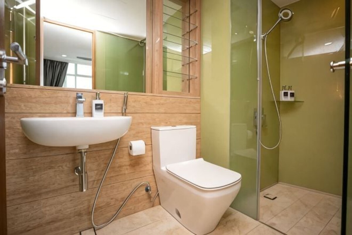 Uma casa de banho moderna com lavatório, sanita e chuveiro.