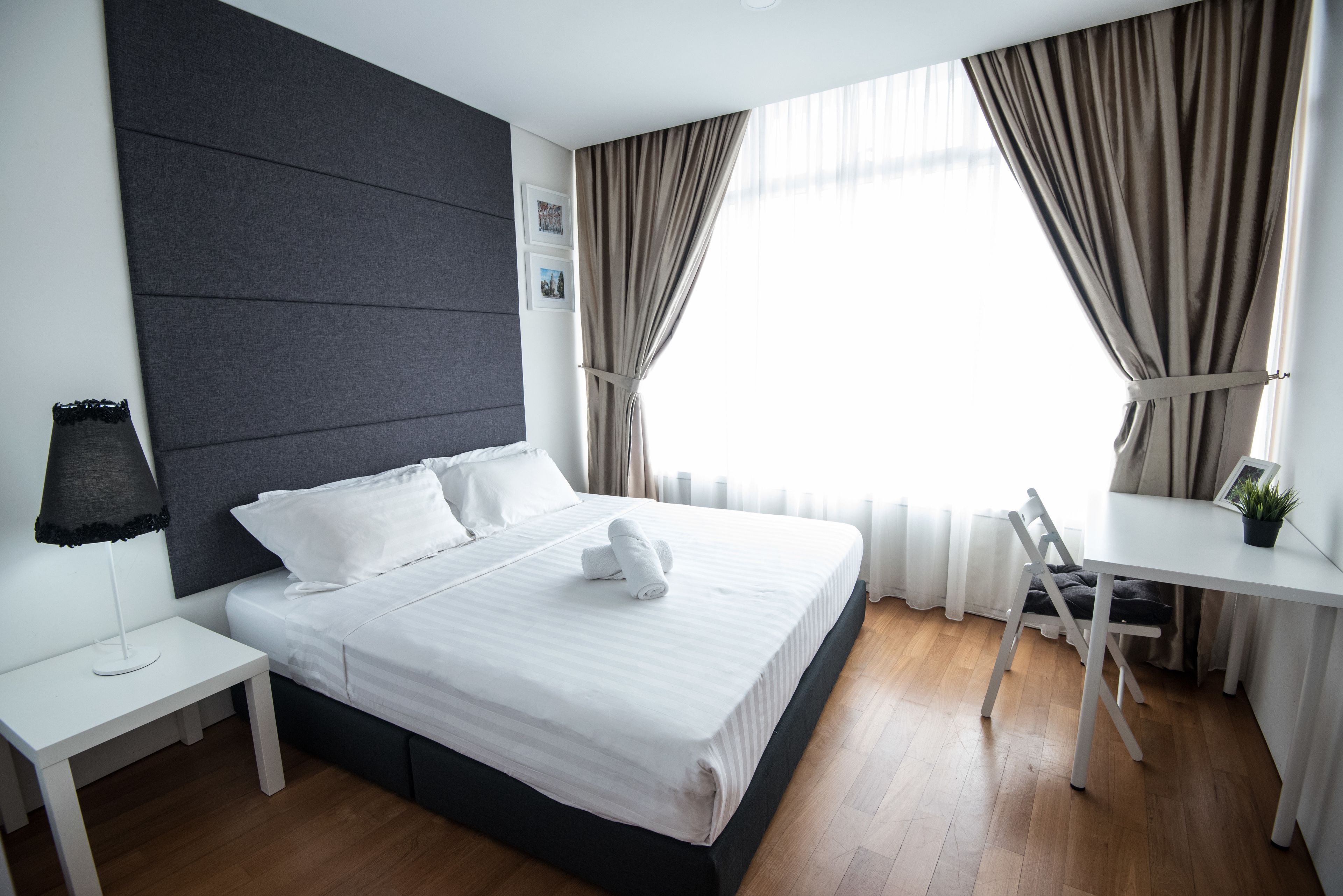 Una habitación de hotel moderna con una cama grande, un escritorio y una silla.