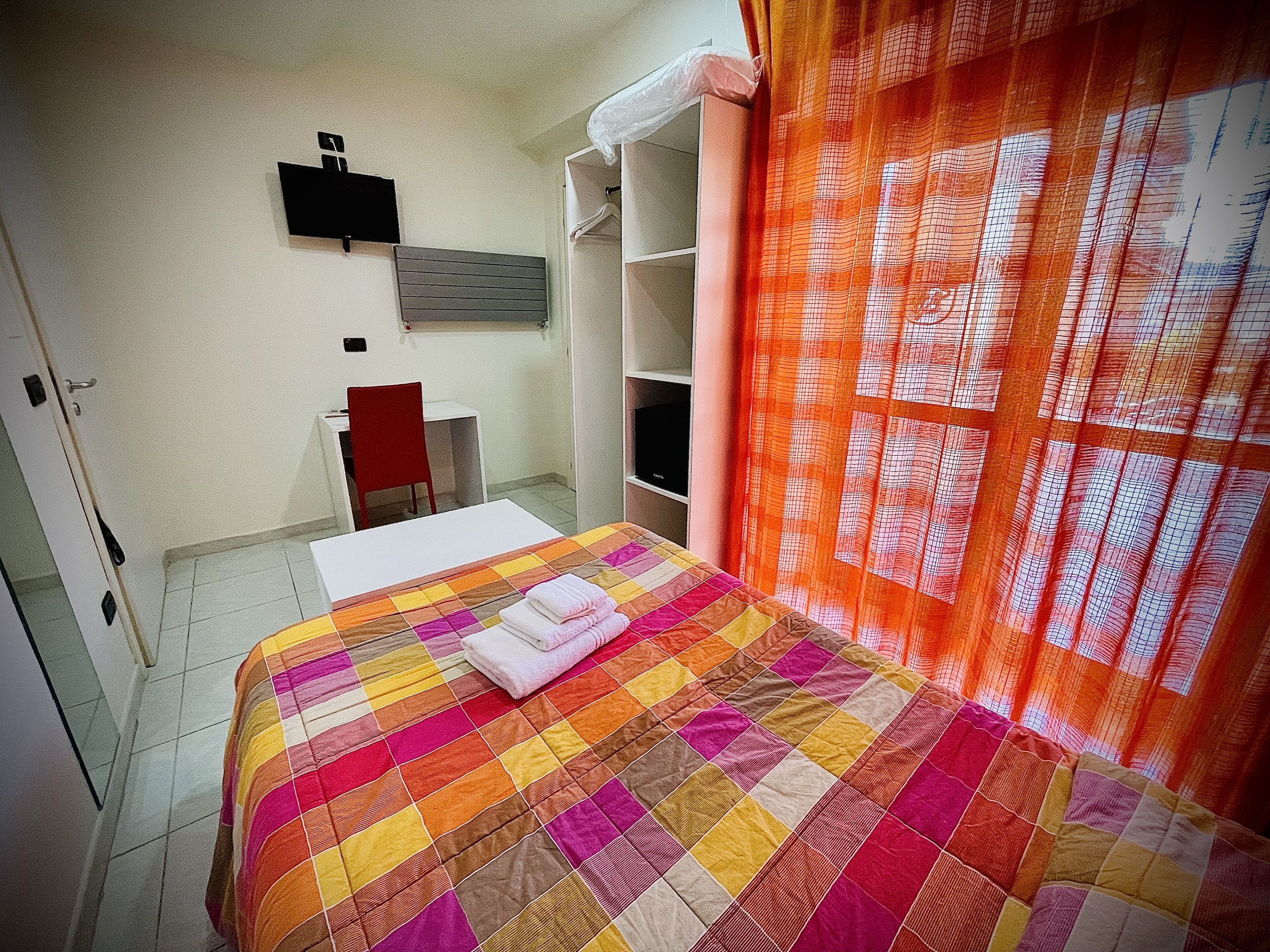 A room with a bed, a desk, and a chair.