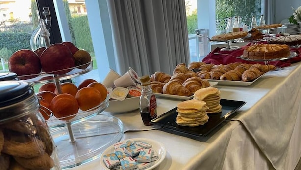 Un bufé de desayuno con diversas opciones de pastelería, frutas y galletas.
