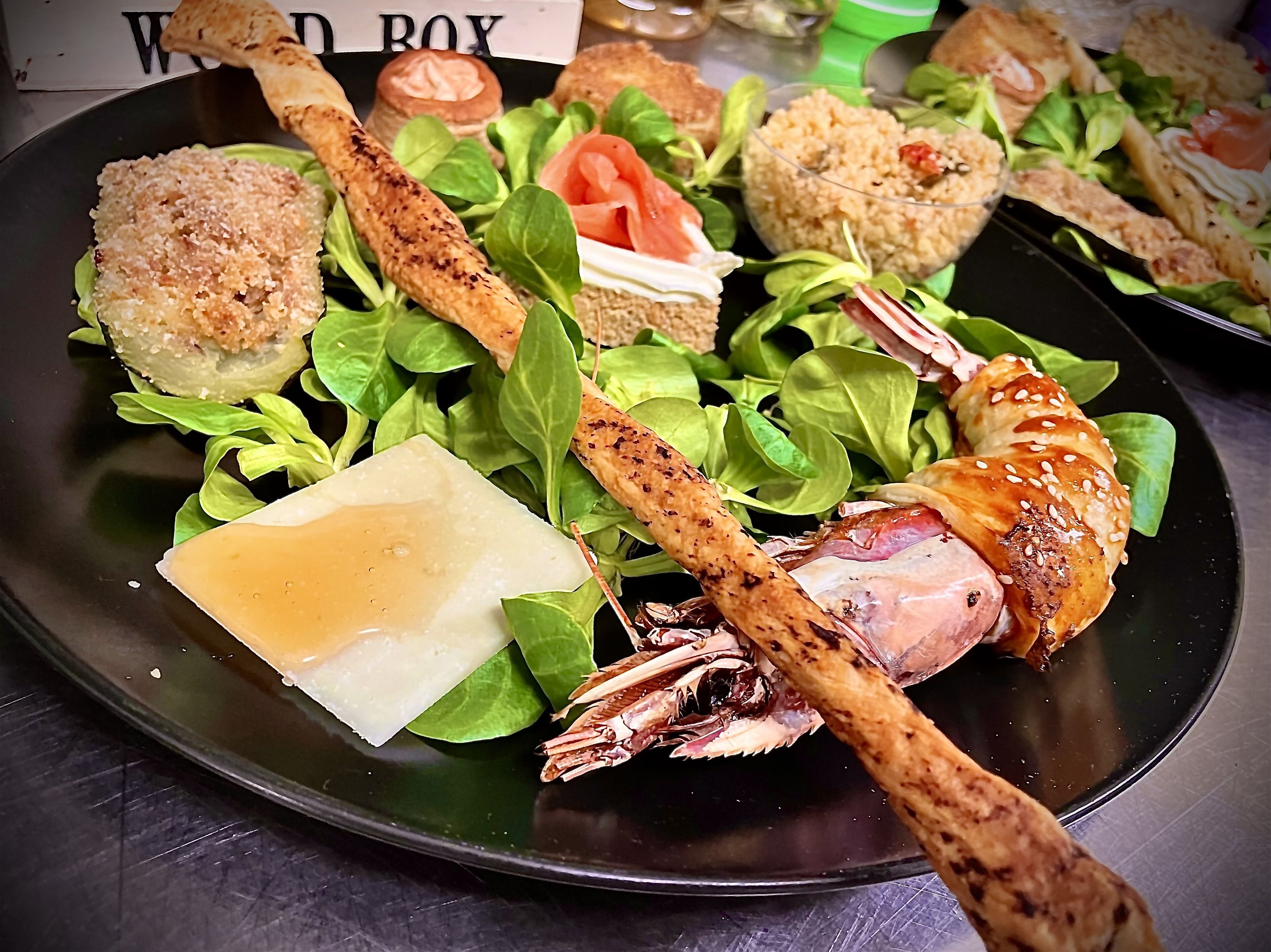 A plate of food with various items including breaded chicken, a piece of cheese, and greens.