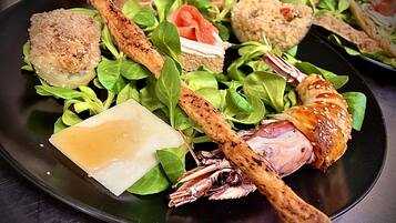 A plate of food with various items including breaded chicken, a piece of cheese, and greens.