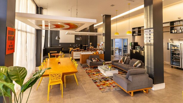 A modern interior with a dining area, sofas, a kitchen, and a bar area. - Ibis Styles Boa Vista (Boa Vista)