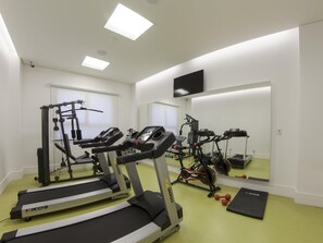 A gym with treadmills, weight machines, and a mirror. - Ibis Styles Boa Vista (Boa Vista)