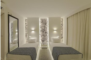 A hotel room with two beds, a mirror, a decorative wall, and a window with curtains. - Ibis Styles Boa Vista (Boa Vista)