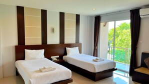 Une chambre d’hôtel avec deux lits, un balcon offrant une vue agréable et un design moderne.